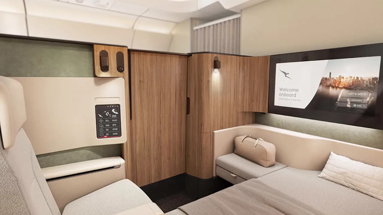 Modern premium cabin suite with privacy wall, bench seating, and entertainment screen
