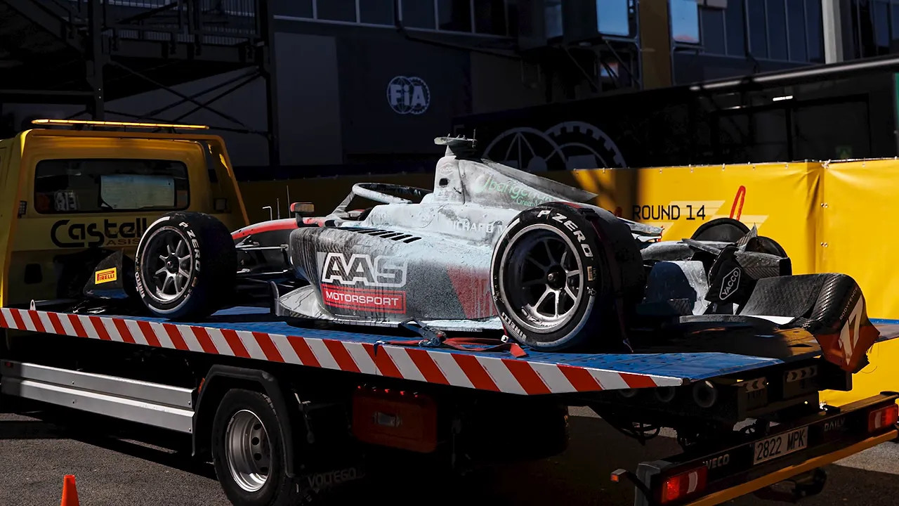 Damaged Formula 2 car covered in fire retardant on a recovery truck