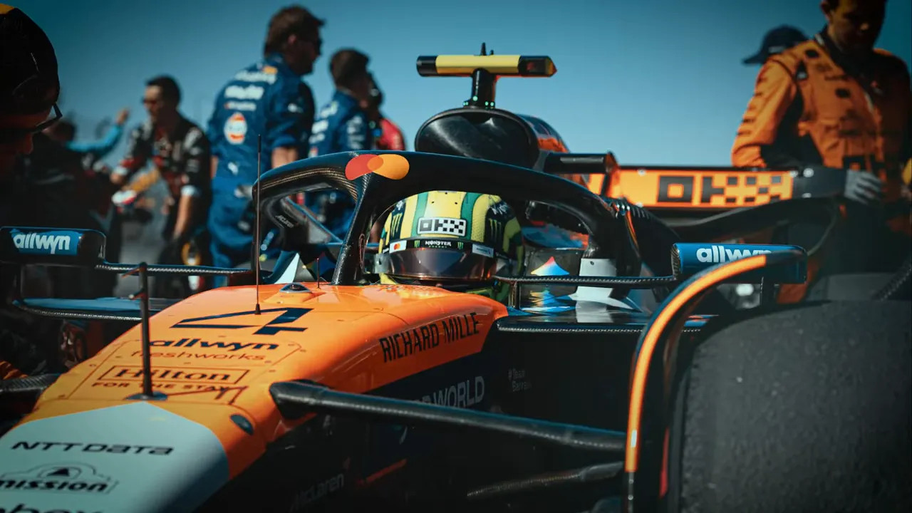 Lando Norris using a tape marker on the pit wall to line up his car