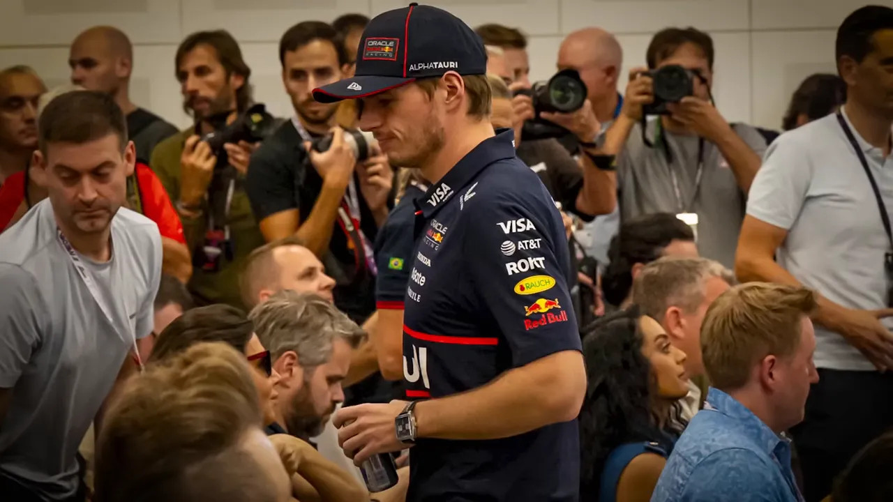 Driver moving through a crowded media room while photographers take pictures