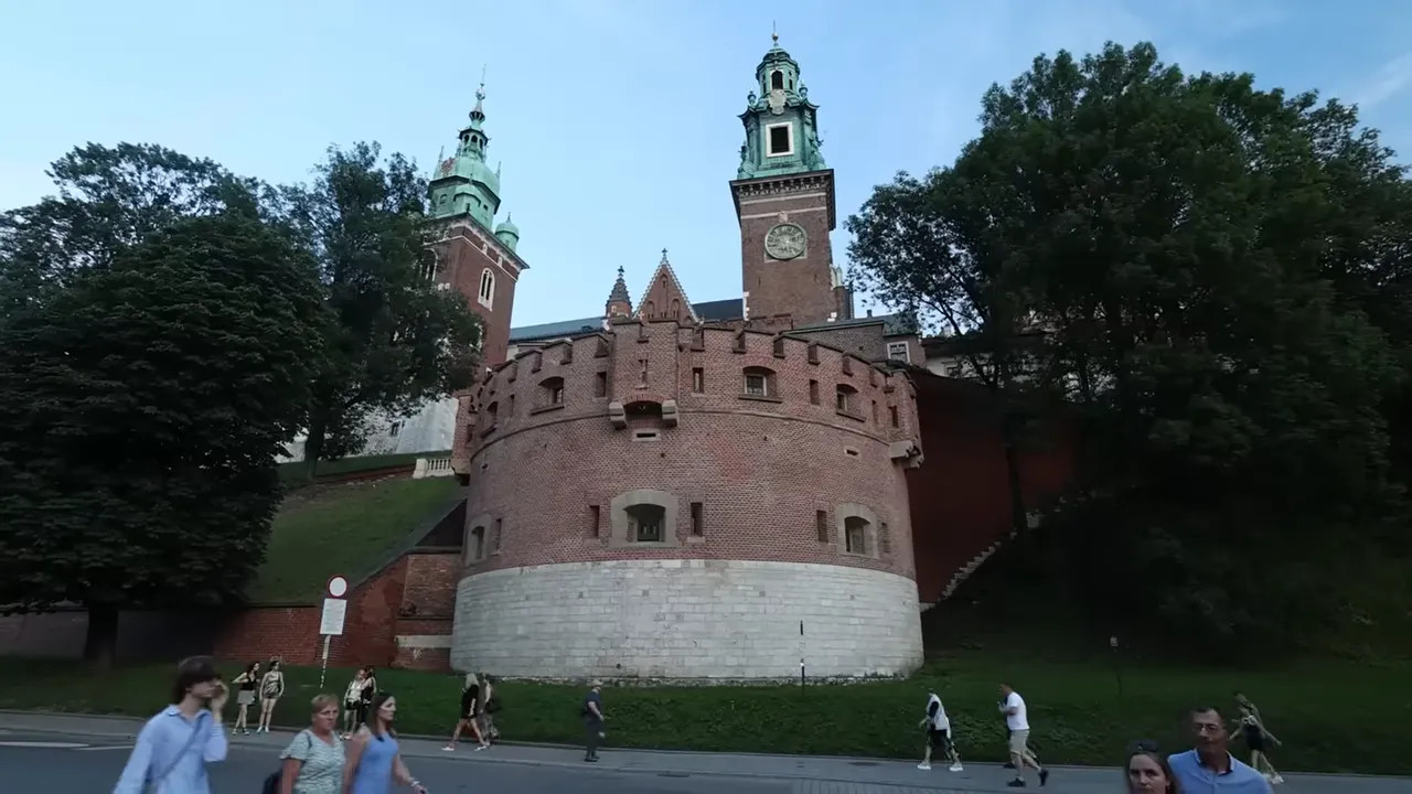 brick fortification and tower of Wawel Castle on a grassy rise