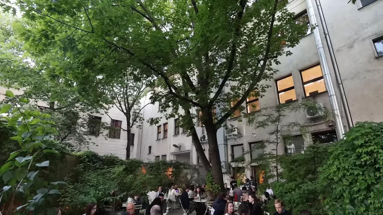 courtyard garden dining area with tables under a large tree