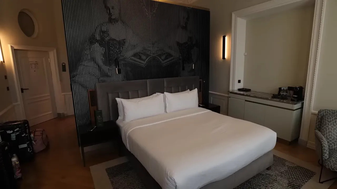 hotel room with large bed chairs and small round table