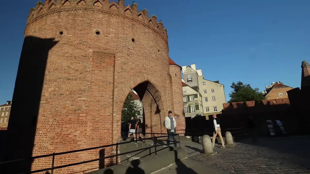 large round brick gate tower with people walking through the arch