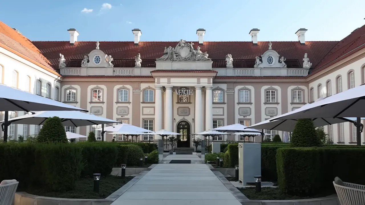 ornate courtyard facade of Hotel Verte with umbrellas and central walkway