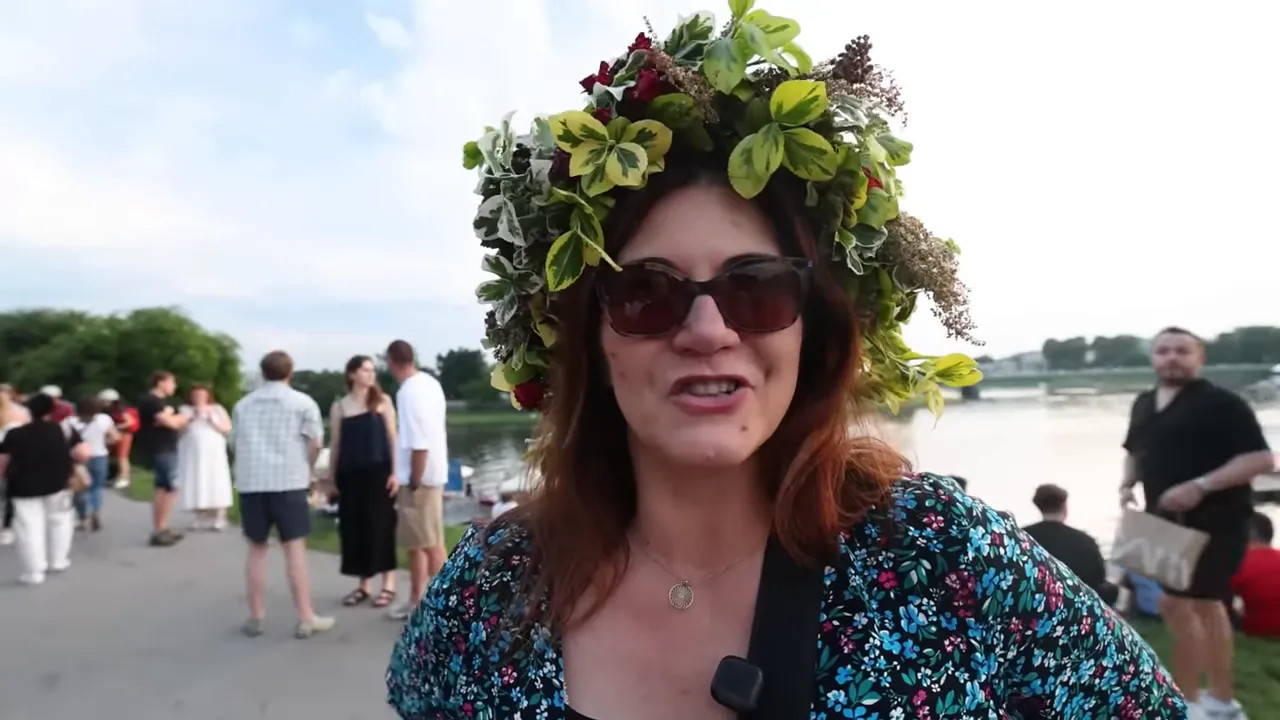woman wearing a large green floral wreath beside the river