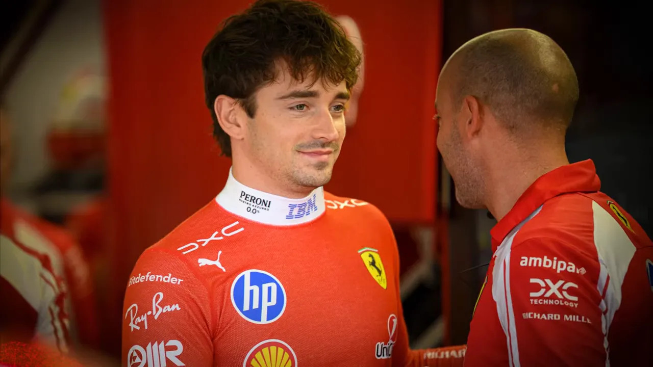 Charles Leclerc clasping hands with a Ferrari team member inside the garage