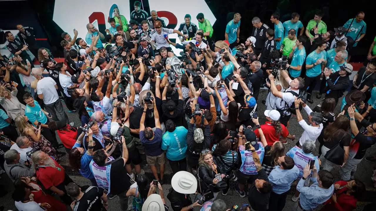 Overhead view of a crowded Mercedes celebration in the paddock