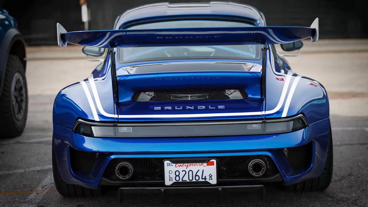 Rear of a blue-and-white Porsche with Brundle lettering and a large rear wing