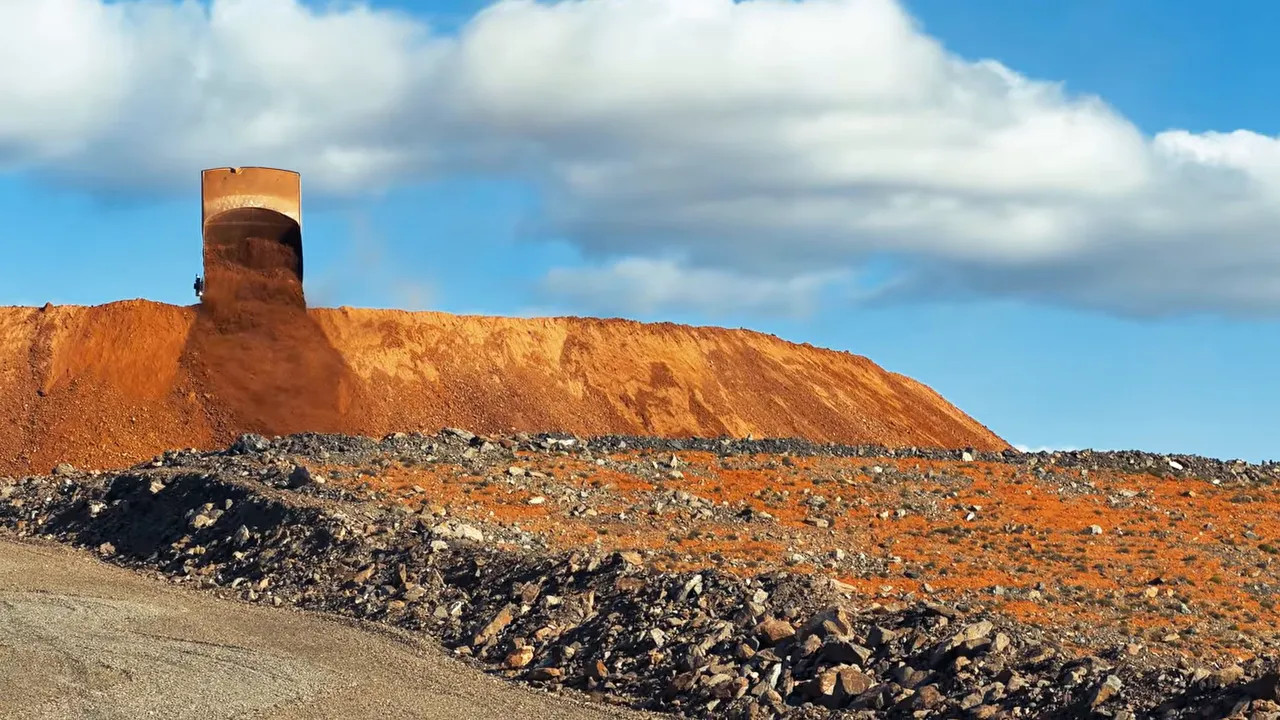 Raised red earth tailings embankment with a cylindrical structure on top