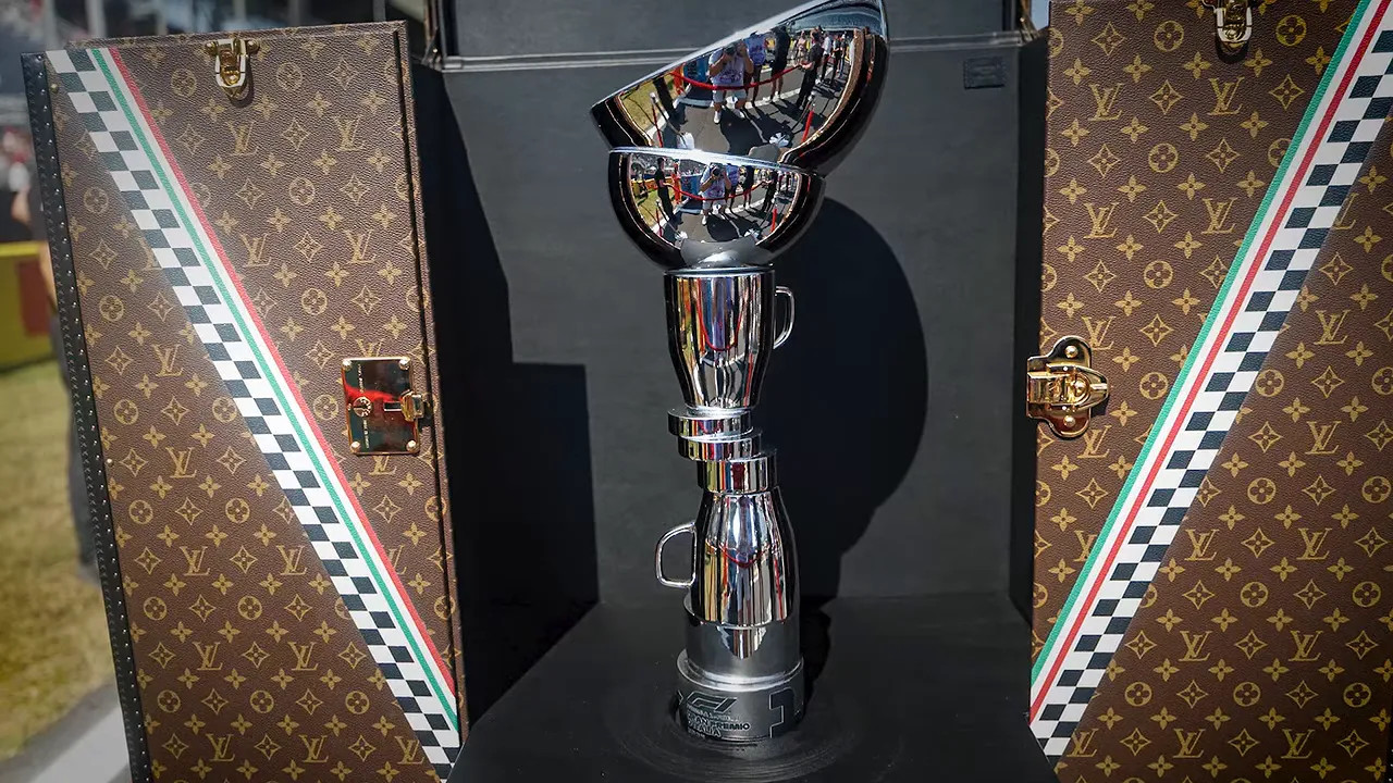 Silver Italian Grand Prix trophy displayed between two patterned cases