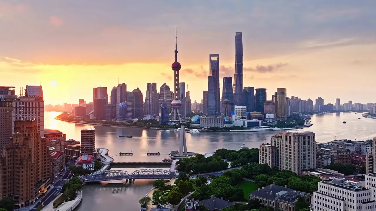 Shanghai Pudong skyline at sunrise with the Bund and the Huangpu River in the foreground.