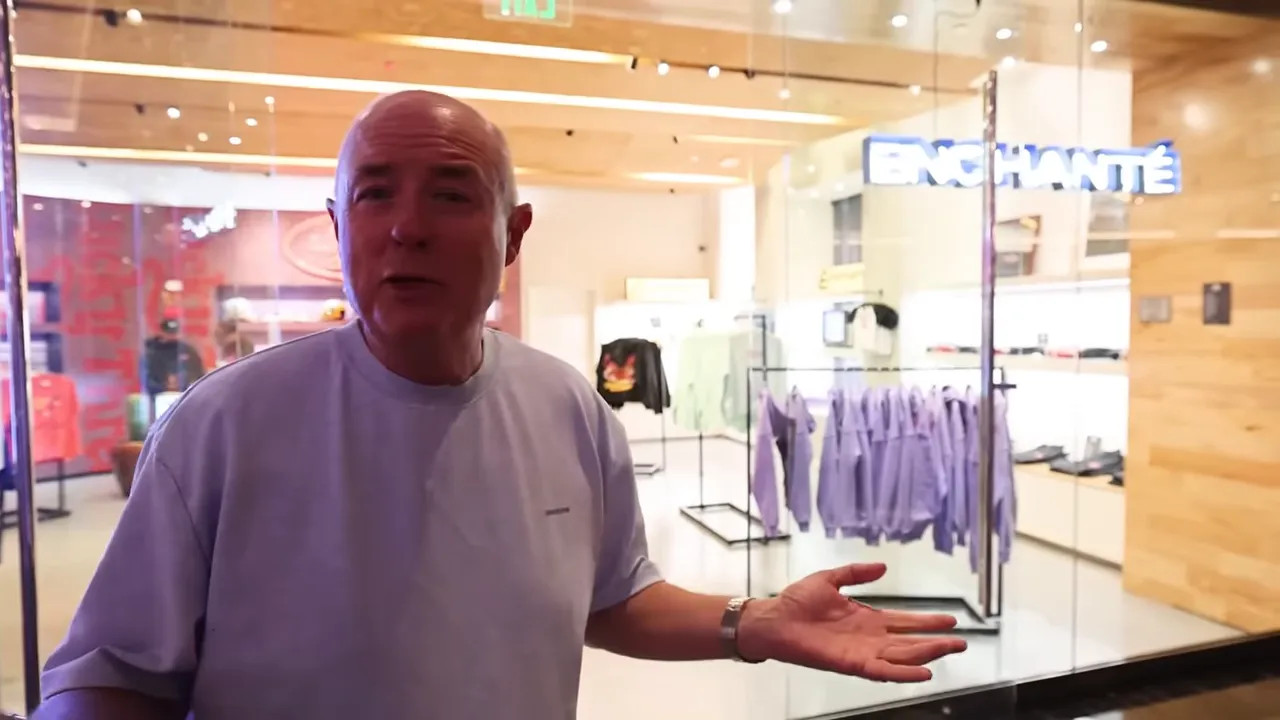 Person gesturing in front of the Enchanté pop-up shop showing purple apparel and glass storefront