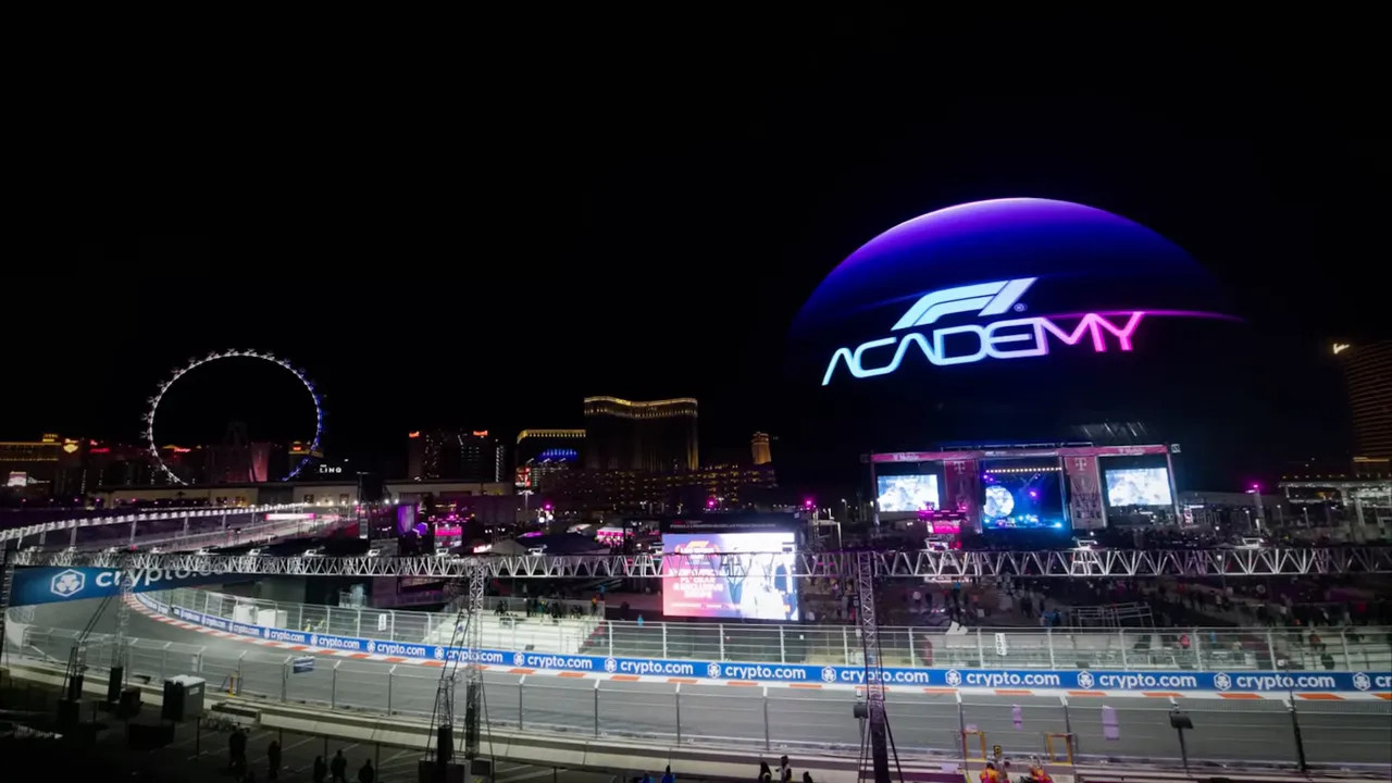 Wide night shot of the circuit with stage, crowd area and large illuminated F1 dome in Las Vegas