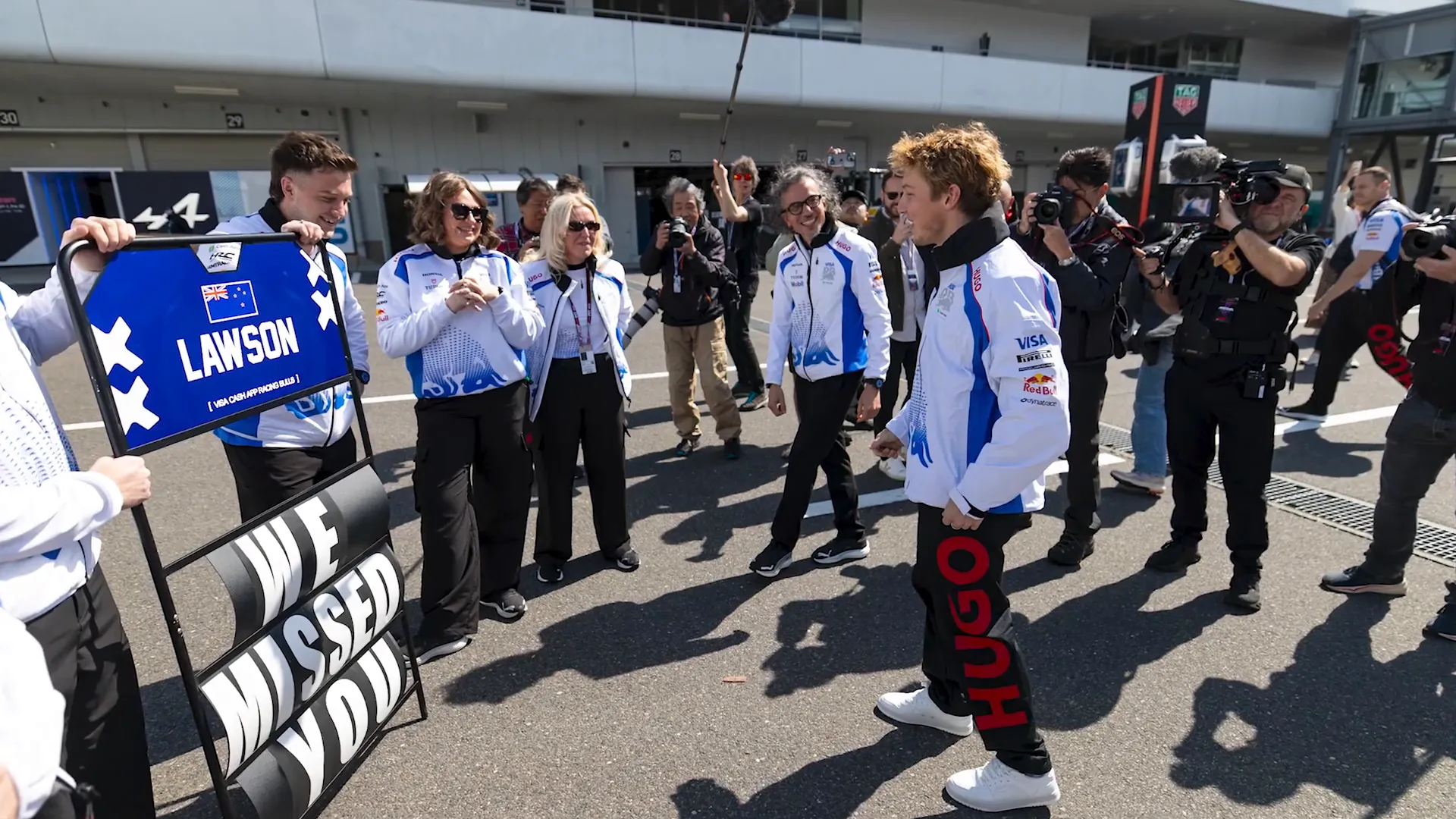 Team members greeting Liam Lawson