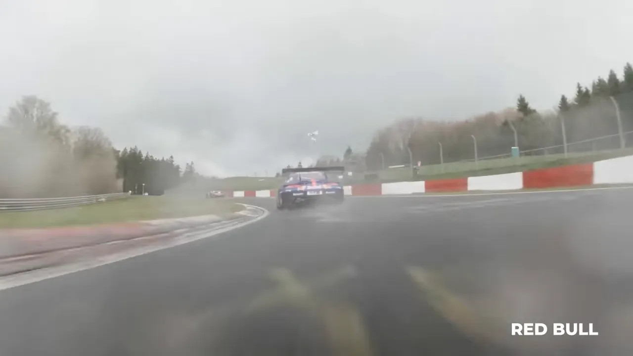 GT3 car ahead in fog on the Nürburgring circuit during low-visibility conditions