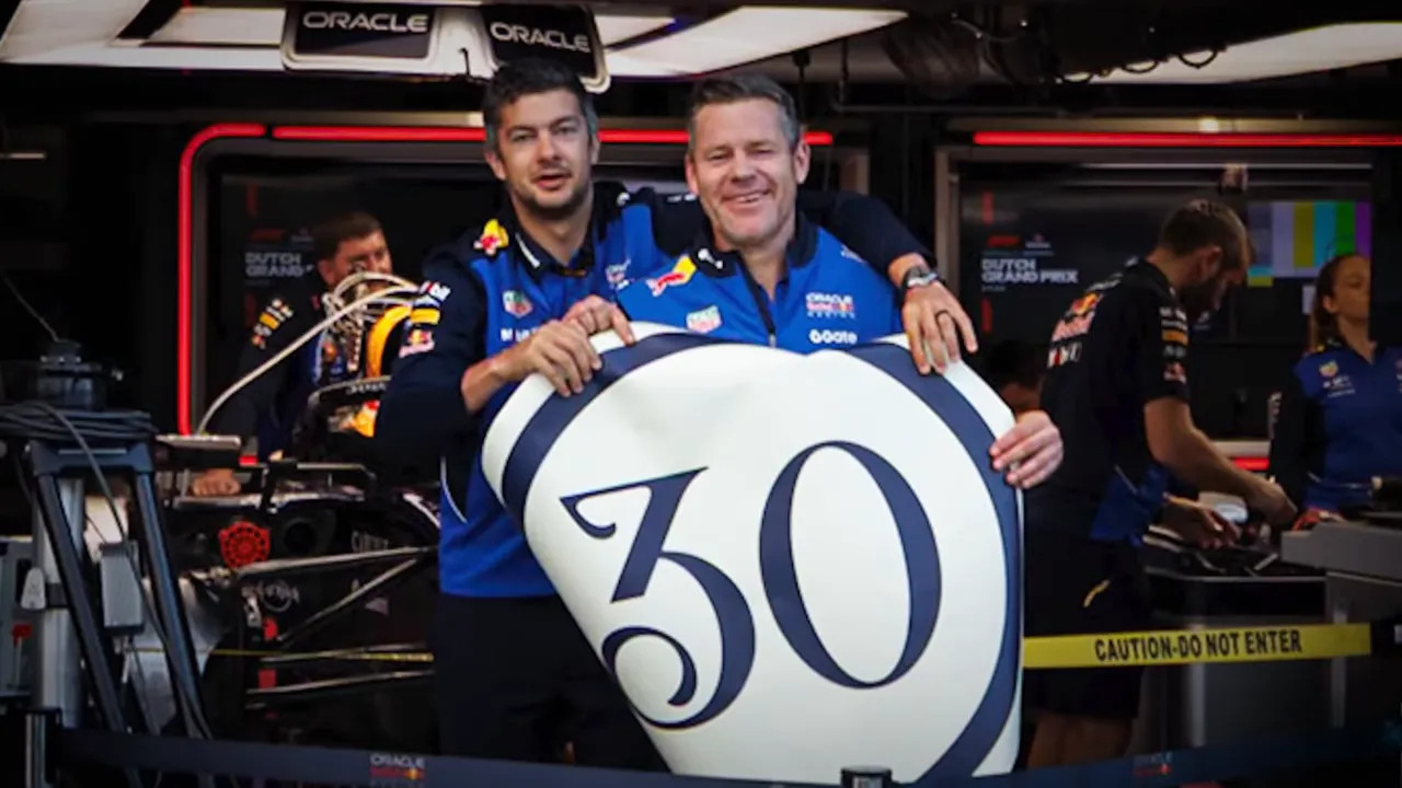Liam Lawson and a Red Bull team member hold a large sign with the number 30