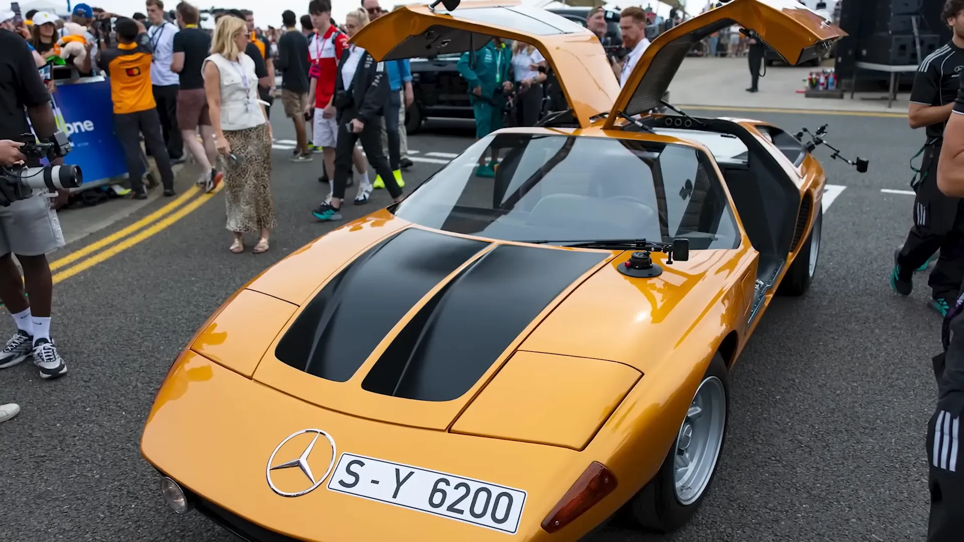 George Russell driving the Mercedes C111 with the door open arriving at Silverstone
