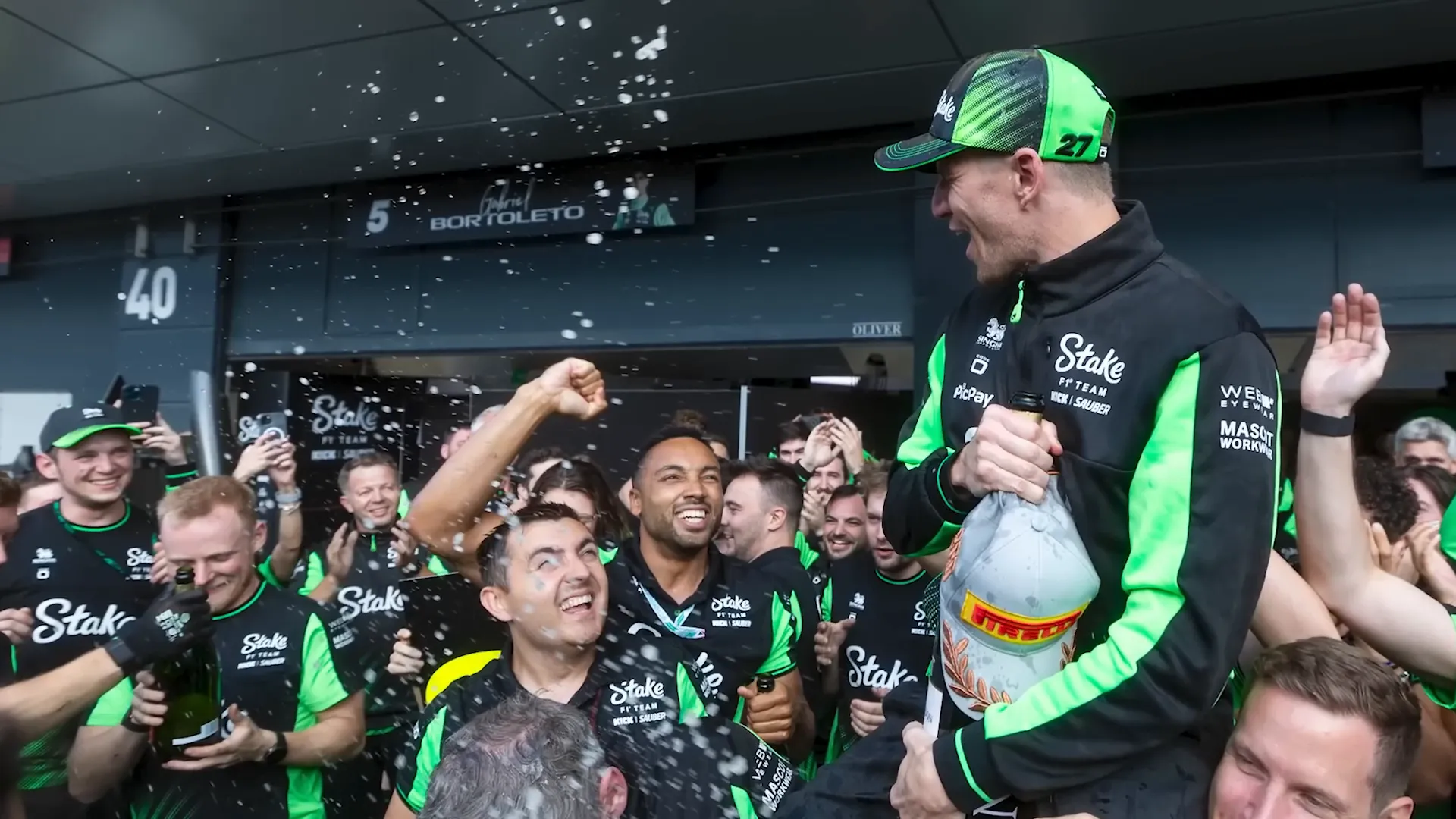 Sauber mechanics celebrating with Nico Hulkenberg and trophy in the wet