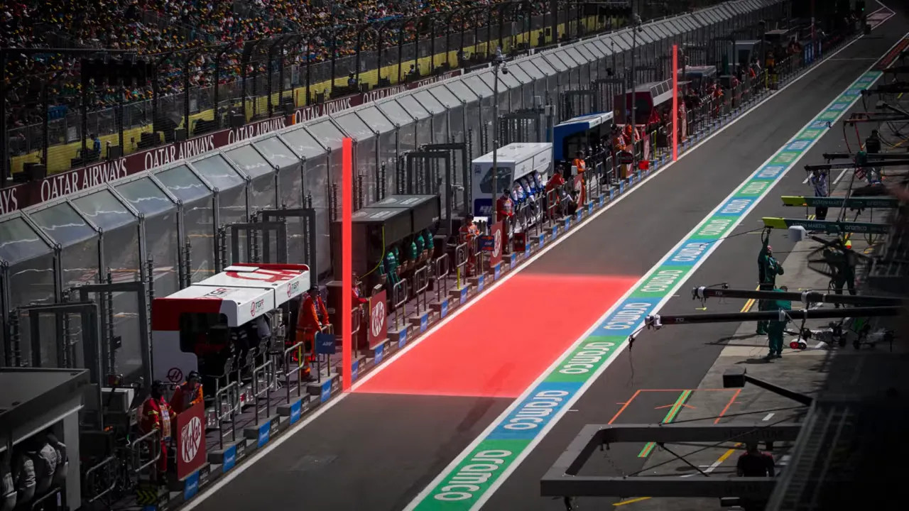 Illustration of a pit lane with red highlighted timing sections and vertical markers along the lane