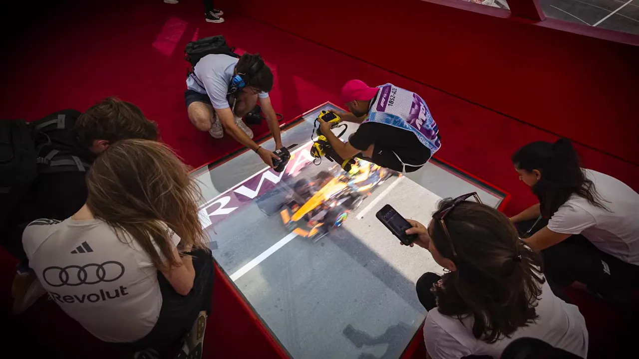 Photographers kneeling around glass floor panels inside a red pedestrian bridge