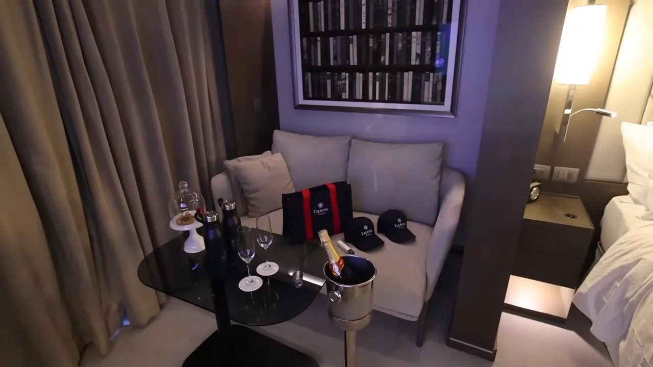 Cruise ship cabin with bed sofa table and interior lighting