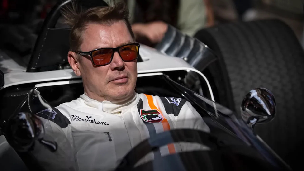 McLaren group photo on the Monaco grid with a historic white car and a modern orange car