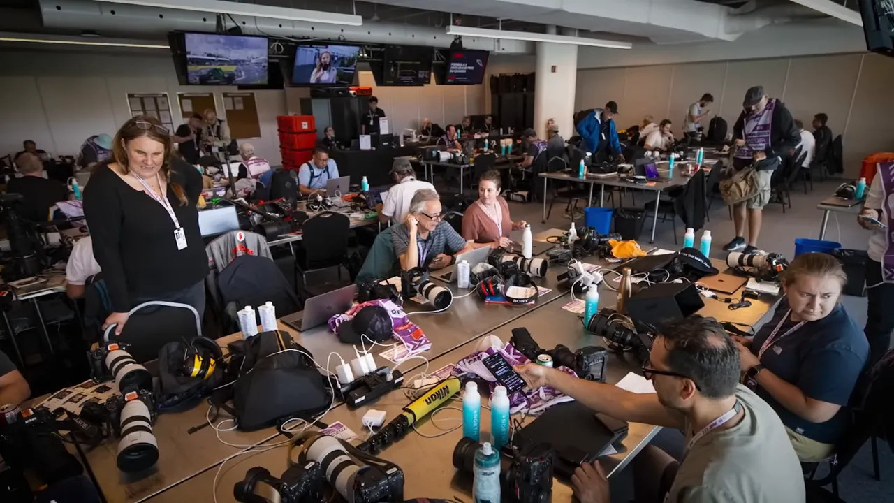 large Formula 1 media centre with desks laptops and people working