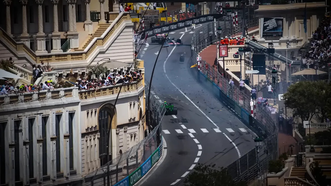 marshal and photographers gathered around a crouched photographer beside the Monaco track