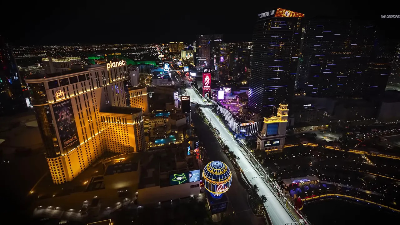 Aerial night shot of the Las Vegas Strip with illuminated hotels and the Formula 1 street circuit lit for racing