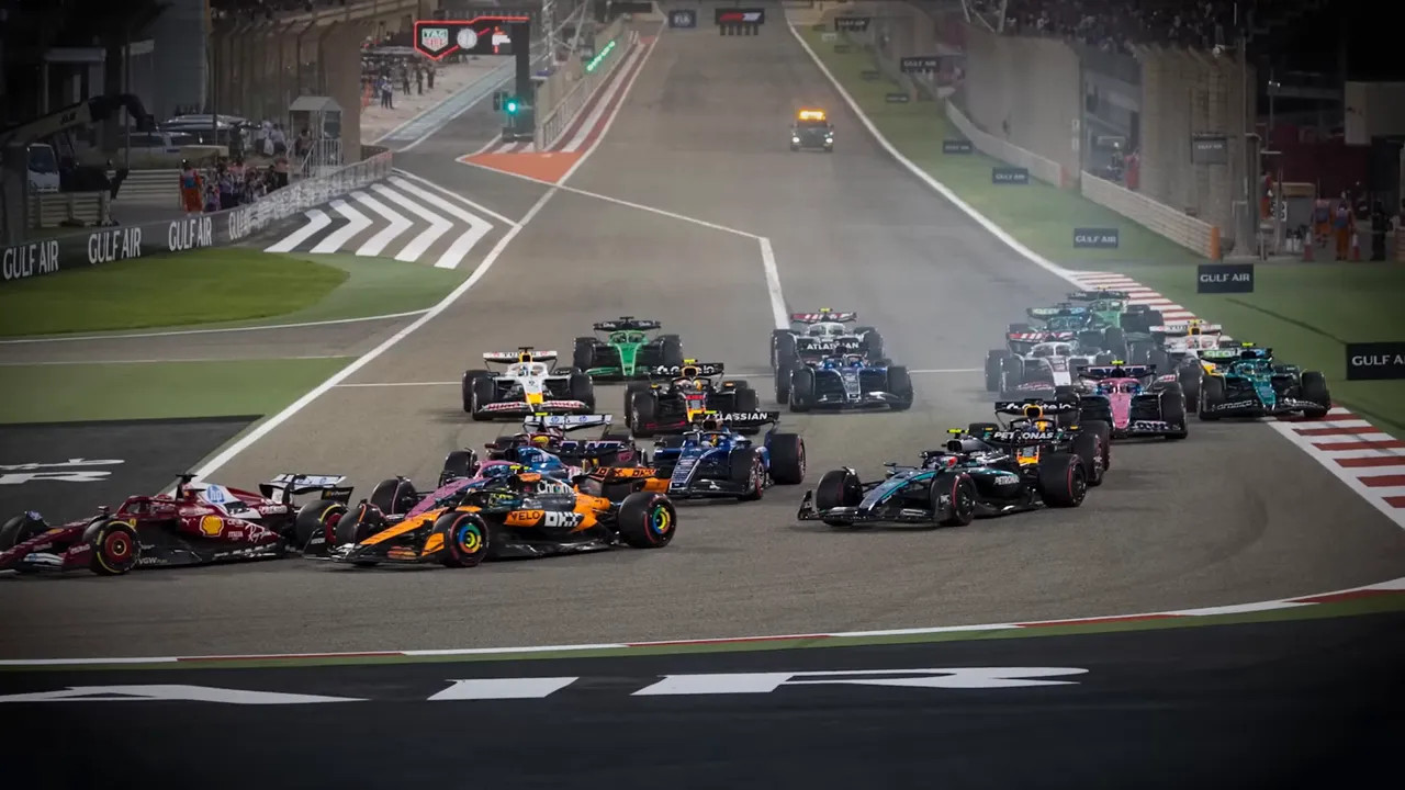 Formula 1 cars jostling at the race start under floodlights at Bahrain International Circuit
