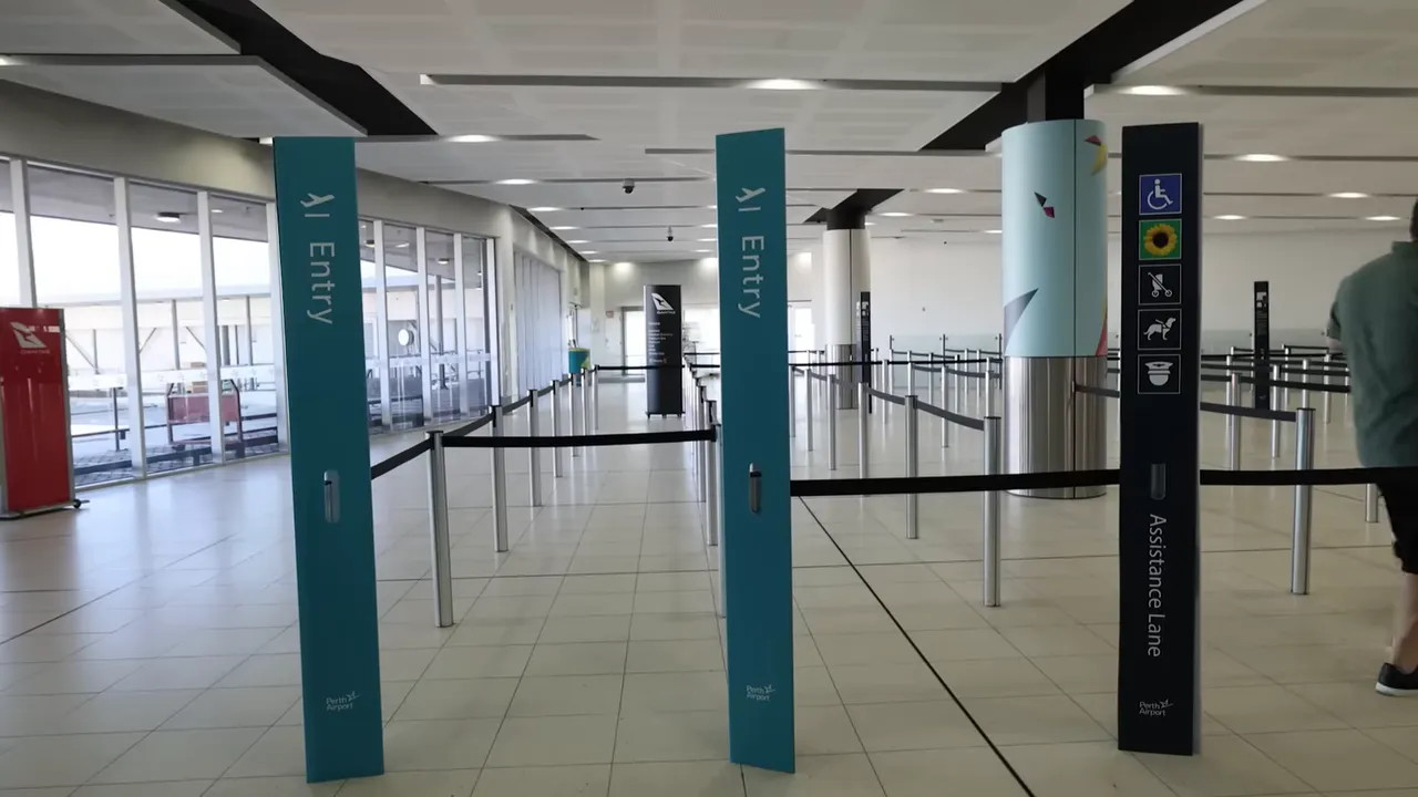 empty security entry lanes with 'Entry' posts and assistance lane signage at Perth Airport