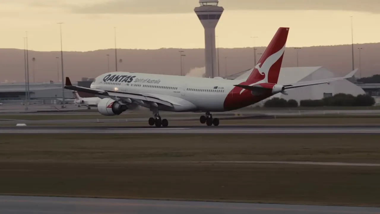 Qantas widebody aircraft landing on runway with airport control tower in the background.