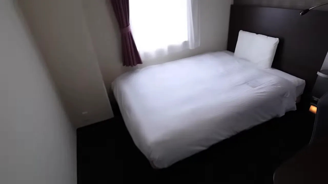 Small hotel room with single bed and window, representing typical race-week accommodation