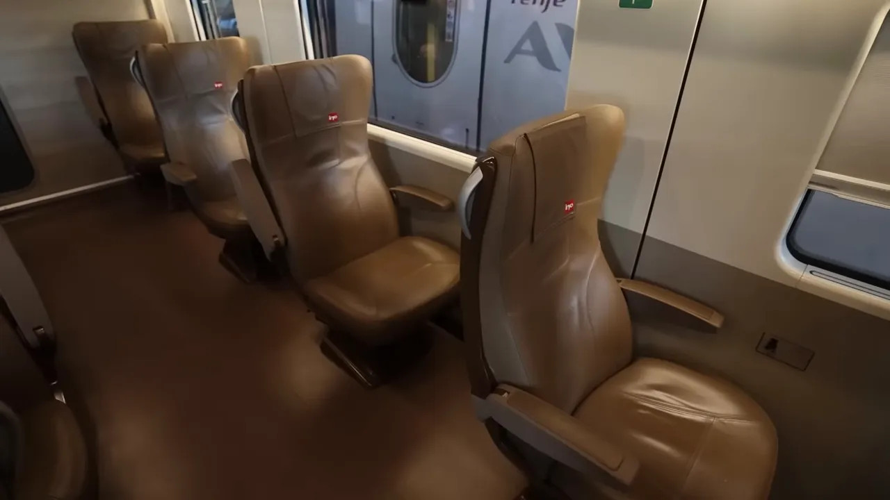 Brown leather train seats in a first class cabin