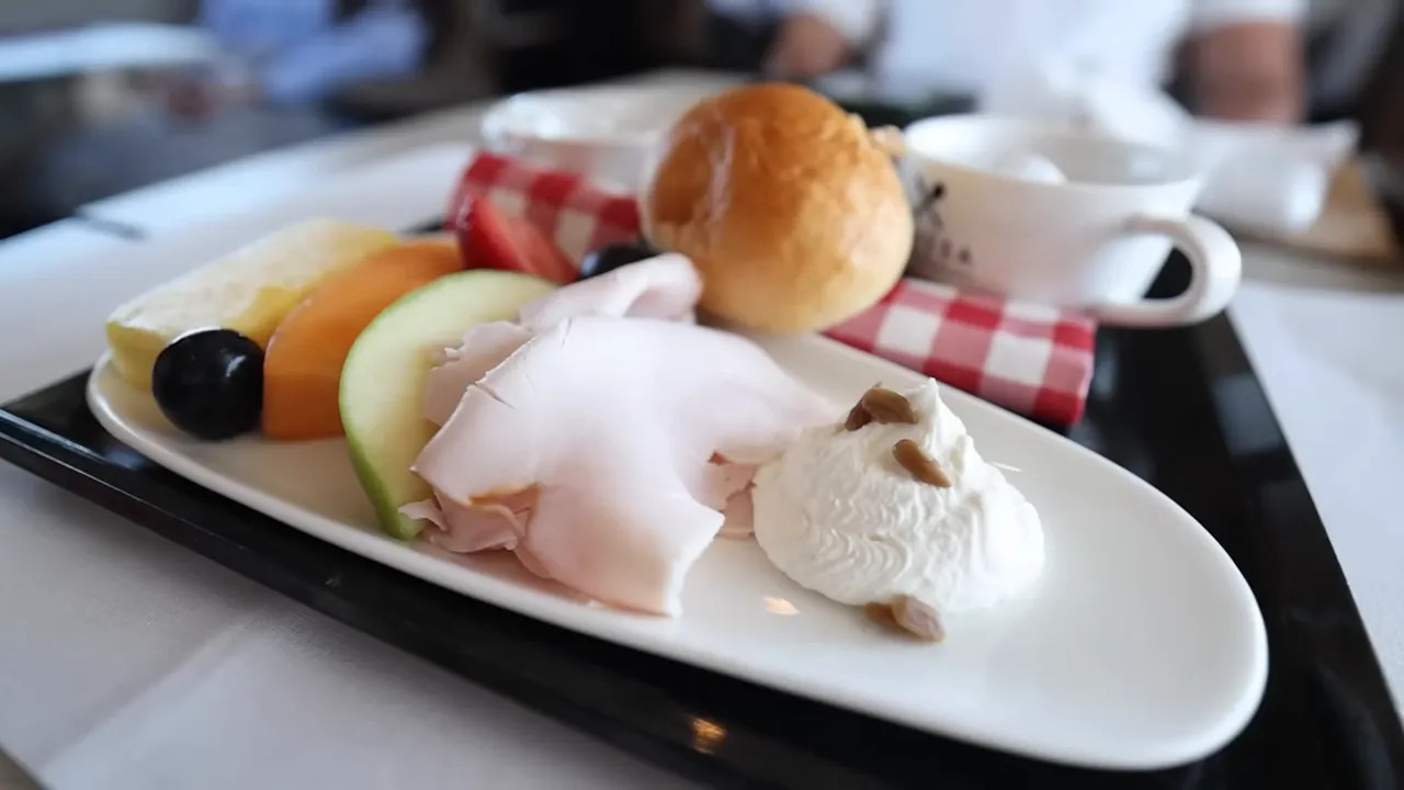 Train breakfast tray with fruit yogurt cold cuts and bread roll