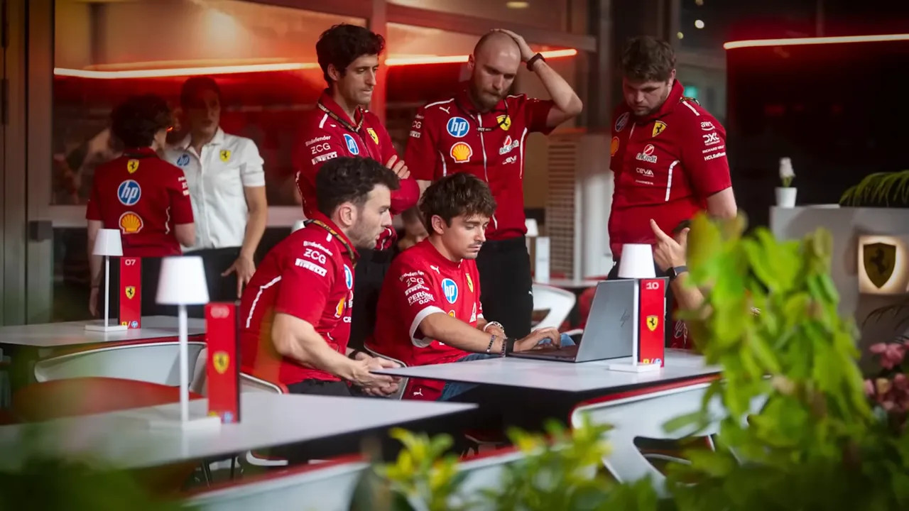 Ferrari team engineers working in a garage environment during a Formula 1 weekend