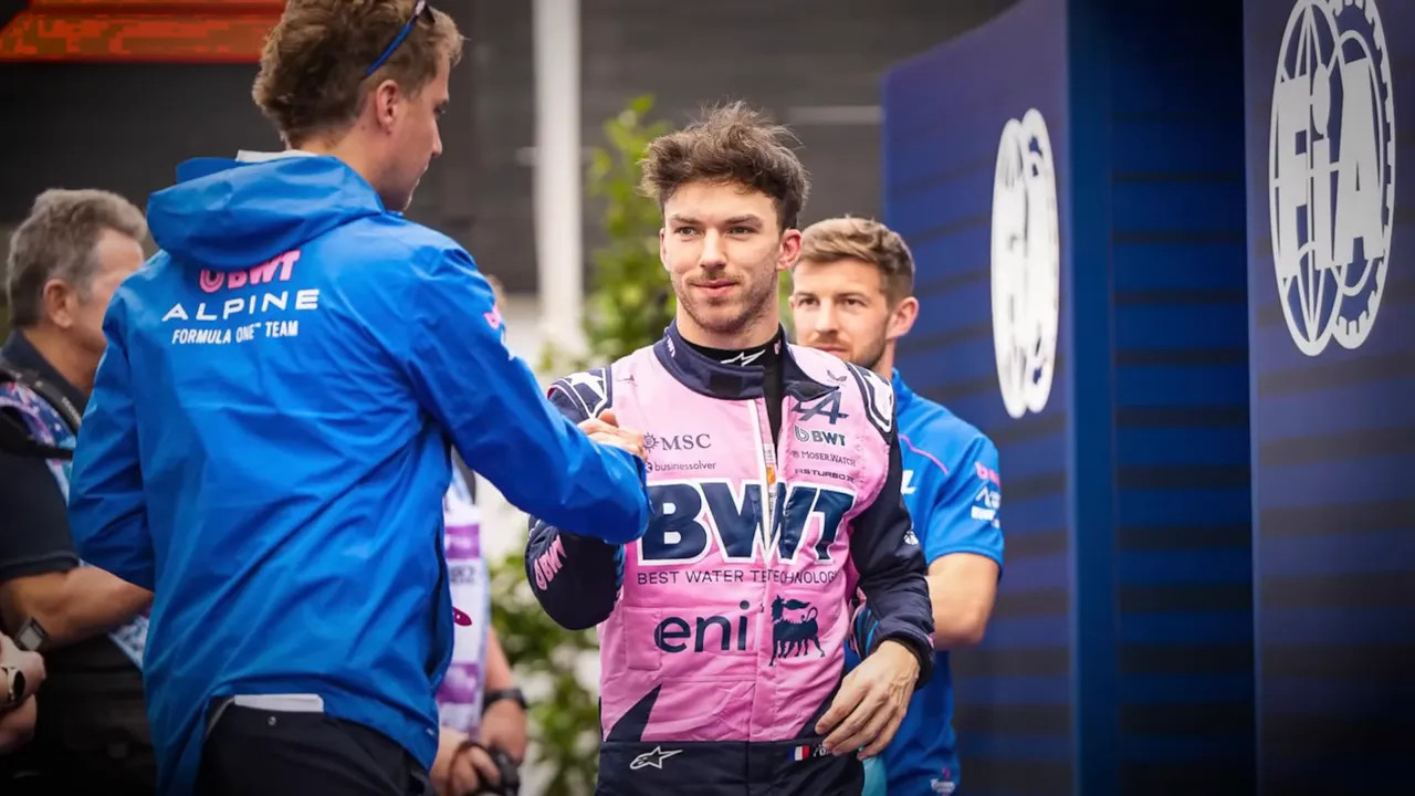 F1 press officer briefing a driver outside the media pen before an interview