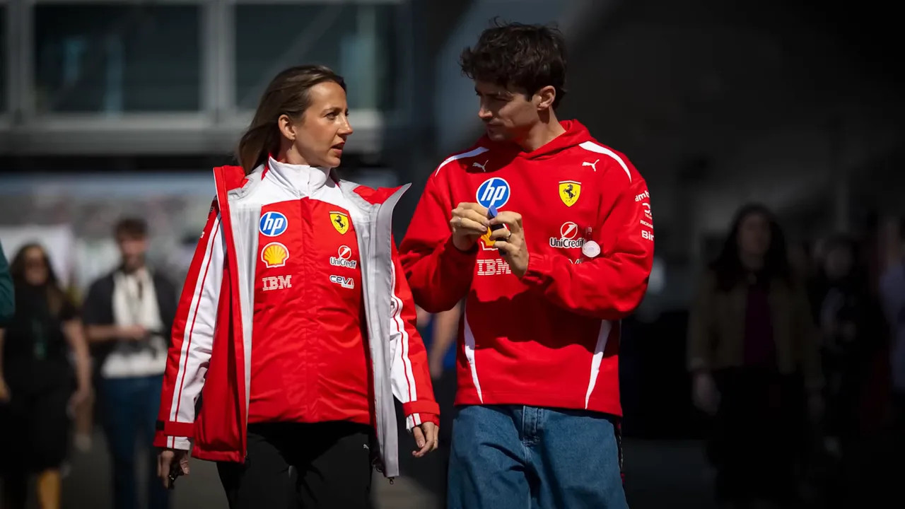 Ferrari team personnel walking and speaking with a driver in red racing gear