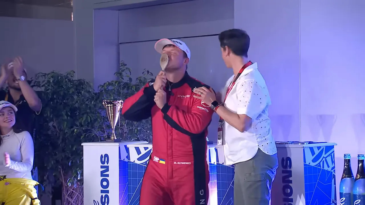 Podium moment with a driver kissing a wooden spoon trophy during the EVO sessions ceremony