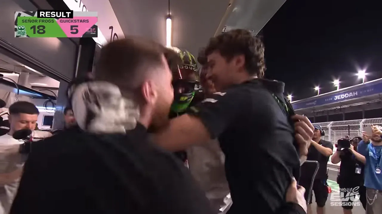 Team members hugging a helmeted driver in the pitlane after the session, with a result graphic visible in the corner.