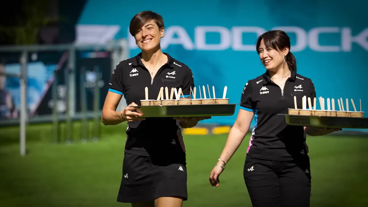 Catering staff wheeling trolleys and setting up food stations in the paddock