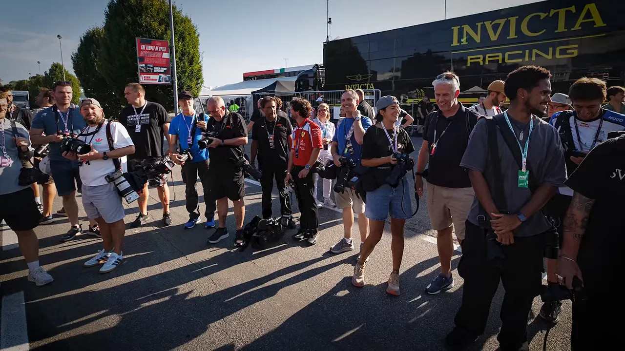 Crowd of media and paddock personnel waiting beside the Monza circuit entrance