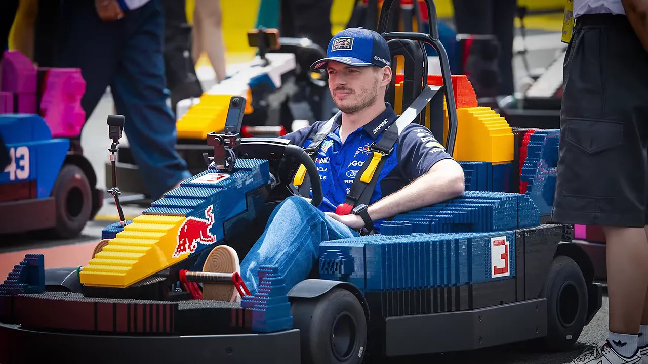 Max Verstappen seated in a blue go-kart wearing a blue racing suit and cap