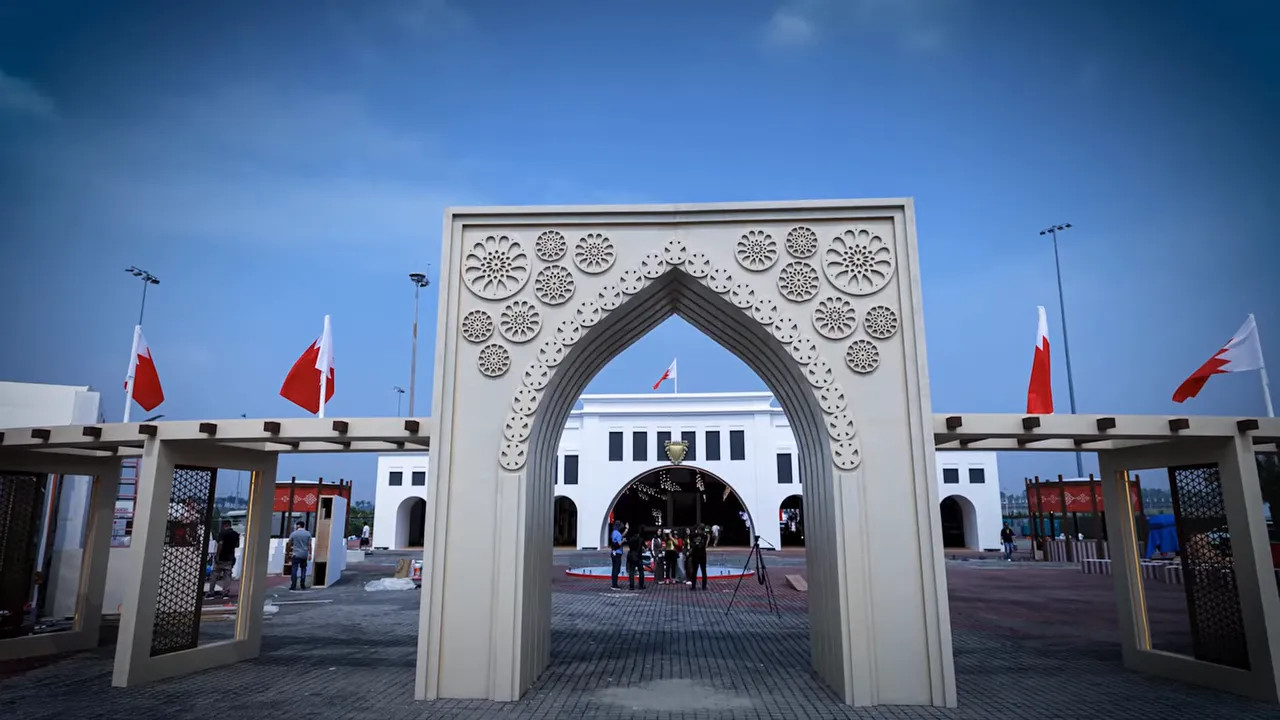 Decorative white archway at Sepang with red-and-white flags on either side