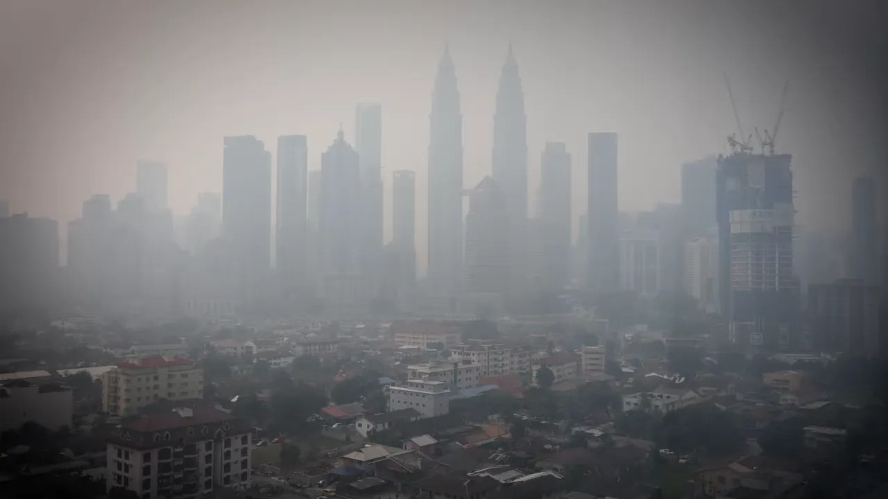 Kuala Lumpur skyline with high-rise buildings partly obscured by haze