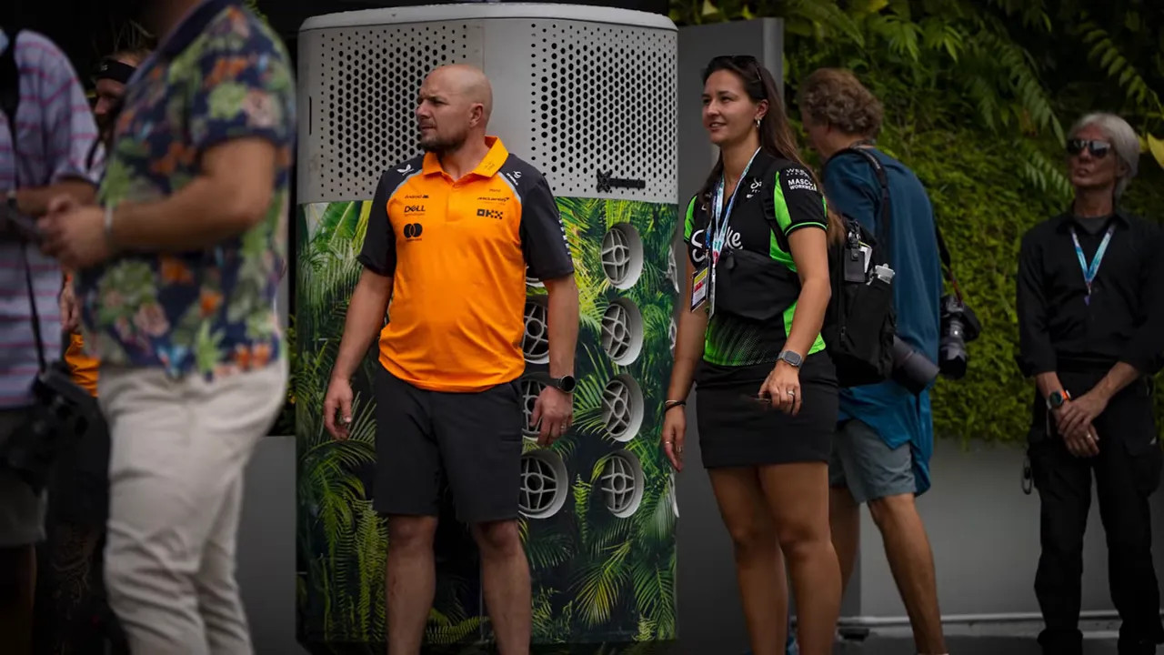 Portable air-conditioning unit standing beside a row of equipment cases outdoors