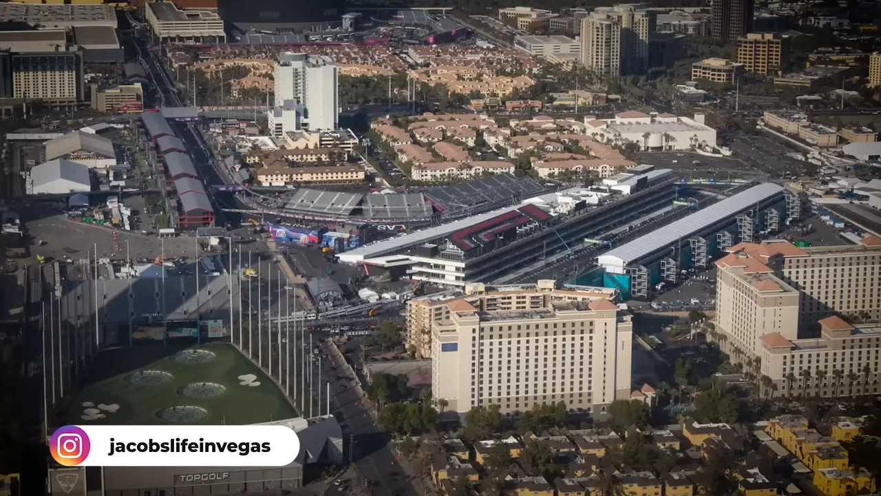 Daytime aerial photograph of the Las Vegas F1 paddock and pit lane with nearby hotels and residential blocks.