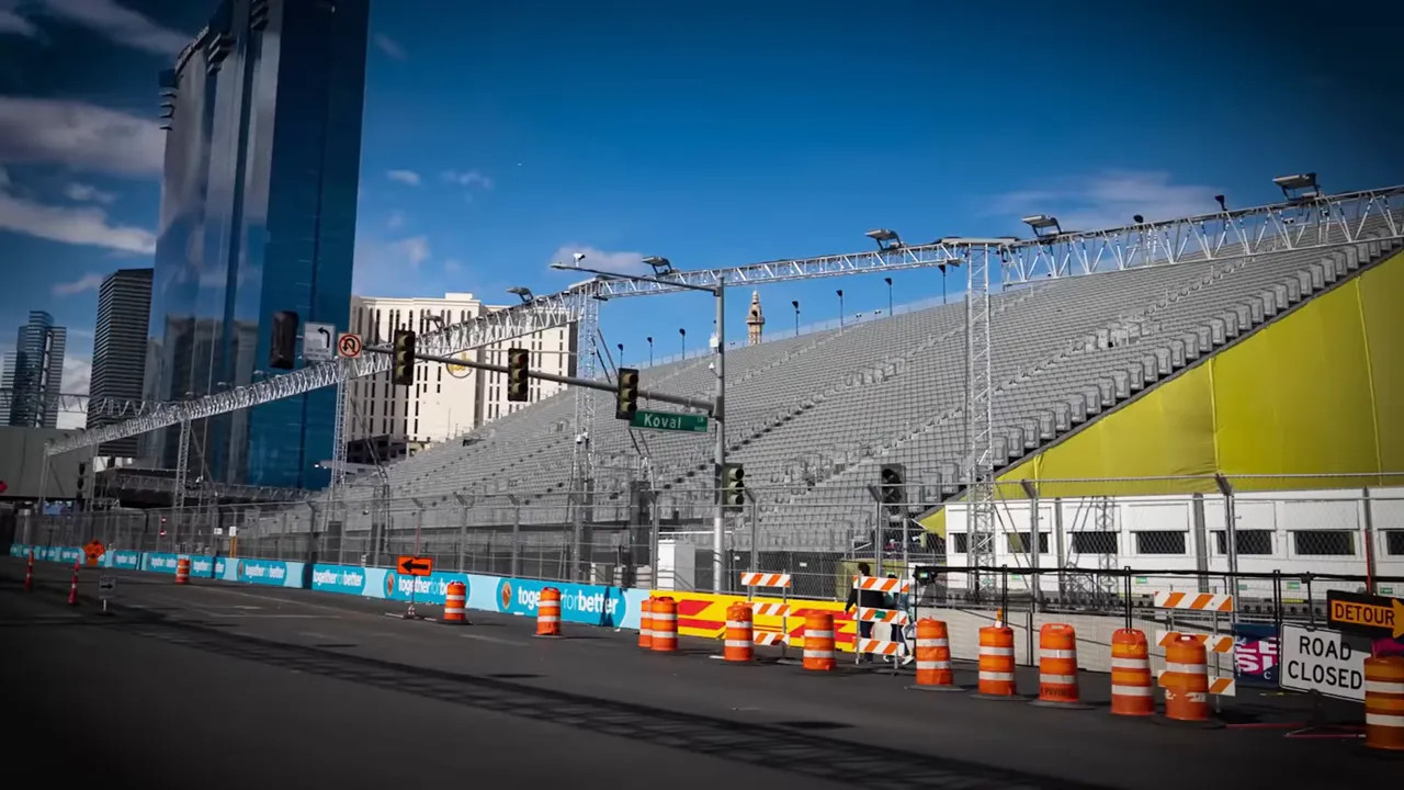 Large tiered grandstand next to the Las Vegas street circuit with safety fencing and road-closure barrels