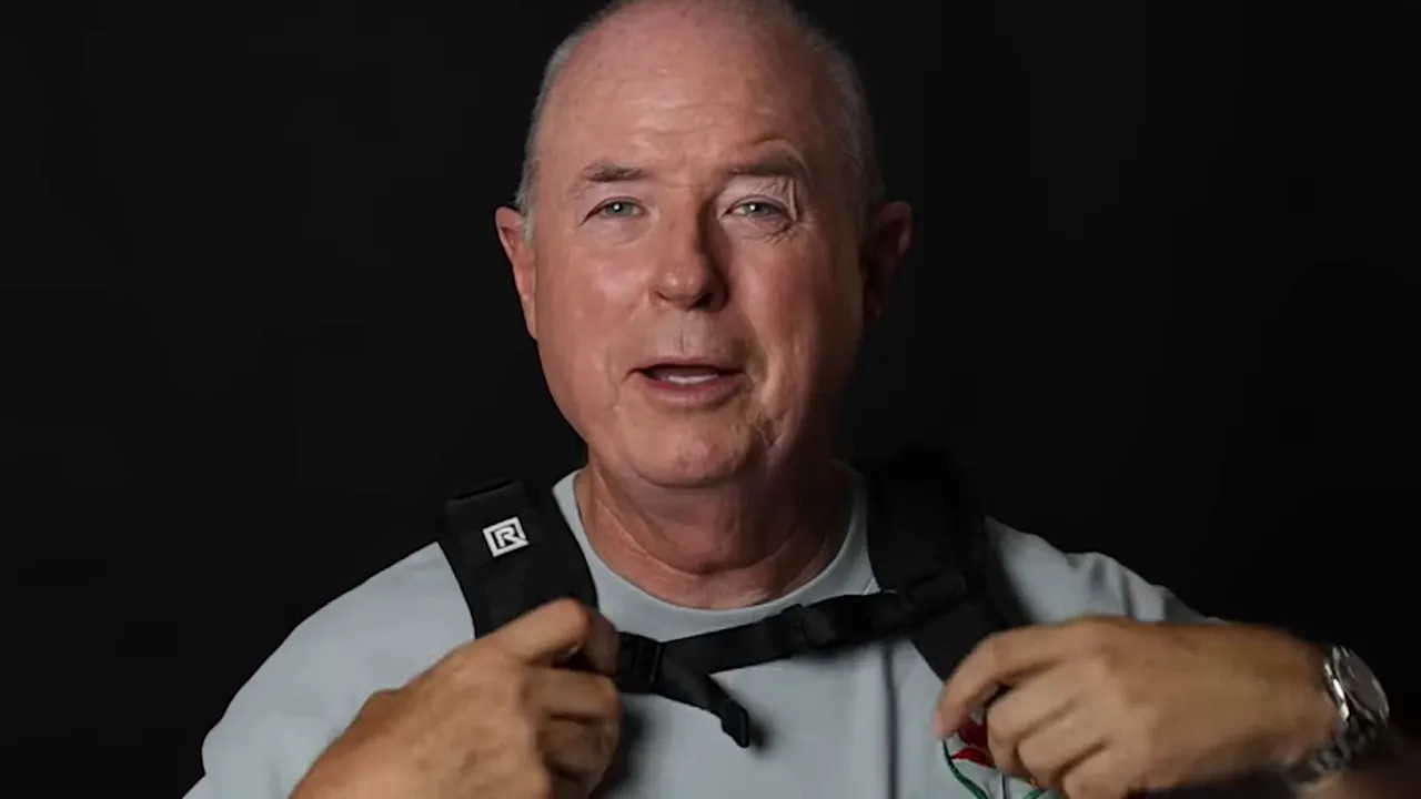 F1 photographer adjusting a camera strap for faster access